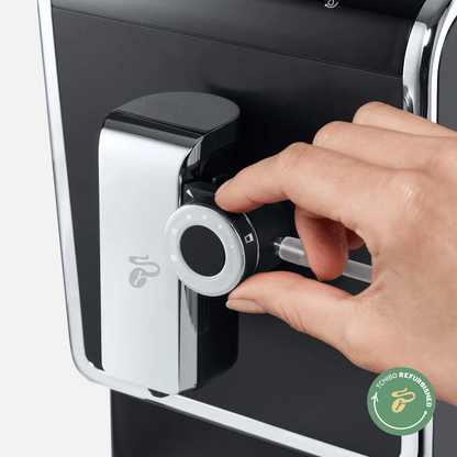 Hand bedient Drehregler am Tchibo Esperto Pro Kaffeevollautomaten mit "Tchibo Refurbished"-Logo